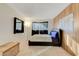 Bedroom with a leather platform bed, wood accent wall, and bright, neutral carpet at 3821 1/2 Daisy St # 25, Las Vegas, NV 89119