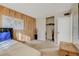 Bedroom with a leather platform bed, wood accent wall, and bright, neutral carpet at 3821 1/2 Daisy St # 25, Las Vegas, NV 89119