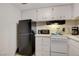 Cozy kitchen with white cabinets and modern black refrigerator at 3821 1/2 Daisy St # 25, Las Vegas, NV 89119