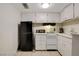 Cozy kitchen with white cabinets and modern black refrigerator at 3821 1/2 Daisy St # 25, Las Vegas, NV 89119