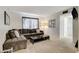 The living room features a large couch, window, and carpet flooring at 3821 1/2 Daisy St # 25, Las Vegas, NV 89119