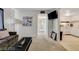 Open-concept living area leading to the kitchen with modern appliances, tile floor, and mounted TV at 3821 1/2 Daisy St # 25, Las Vegas, NV 89119