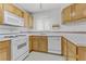 Functional kitchen features white appliances, wood cabinets, and ample countertop space for easy meal prep at 4555 E Sahara Ave # 280, Las Vegas, NV 89104