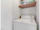 A practical laundry room with a top-load washing machine and overhead storage, enhancing convenience at 4555 E Sahara Ave # 280, Las Vegas, NV 89104