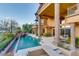 Stunning infinity pool with rock features, lush landscaping, and a luxury home backdrop at 5 Rue De Chateau Pl, Henderson, NV 89011