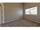 Empty bedroom with neutral carpet, gray walls, and a bright window at 53 Blue Beak Way, Henderson, NV 89012