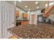 Well-lit kitchen with granite countertops, wooden cabinets, and stainless steel dishwasher at 53 Blue Beak Way, Henderson, NV 89012