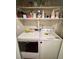 Inside the laundry room featuring white washer and dryer with shelves for storage at 533 Calypso Dr, Henderson, NV 89002