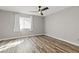 Bright bedroom featuring wood-look floors, neutral paint, and a ceiling fan at 5382 Runningbrook Rd, Las Vegas, NV 89120