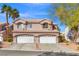 Charming townhome with tile roof, dual garage doors, and desert landscaping under a sunny, blue sky at 5382 Runningbrook Rd, Las Vegas, NV 89120