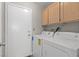 Functional laundry room with side by side washer and dryer and storage cabinets at 5382 Runningbrook Rd, Las Vegas, NV 89120