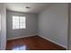 This bedroom has a window with security bars, hardwood floors, and neutral paint at 5461 Dungaree St, Las Vegas, NV 89118