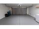 Spacious garage with painted floor, overhead door, and hookups for laundry machines at 5461 Dungaree St, Las Vegas, NV 89118