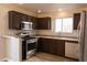 Well-lit kitchen features stainless steel appliances, brown cabinets, and light-colored countertops at 5461 Dungaree St, Las Vegas, NV 89118