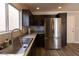 Functional kitchen area boasting stainless steel appliances, dark cabinets, and ample counter space at 5461 Dungaree St, Las Vegas, NV 89118