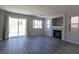 Bright living room with a fireplace, sliding glass doors to the backyard and grey wood flooring at 5461 Dungaree St, Las Vegas, NV 89118