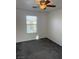 Bright bedroom featuring neutral paint, a ceiling fan, and a window overlooking the neighborhood at 5661 Bonds Flat St, Las Vegas, NV 89148