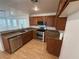 Kitchen showcasing stainless steel appliances, granite countertops, dark wood cabinets, and laminate floors at 5661 Bonds Flat St, Las Vegas, NV 89148