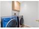 This is a laundry room with a front loading washer and dryer and wood cabinets at 5912 Cuddles Ct, North Las Vegas, NV 89081