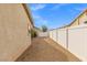 Gravel side yard with a view of the home's exterior and a white vinyl fence at 5912 Cuddles Ct, North Las Vegas, NV 89081