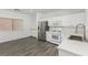 Kitchen with stainless steel refrigerator, white cabinetry and wood-look flooring at 6382 Lonesome Lake St, Las Vegas, NV 89148
