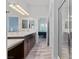 Bright bathroom featuring double sinks with white countertop, wood cabinets, and walk-in shower at 6447 Wide Sky St, Las Vegas, NV 89166