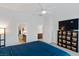 Bright bedroom featuring neutral walls, carpet, ceiling fan, balcony access and a modern storage unit with TV at 6447 Wide Sky St, Las Vegas, NV 89166