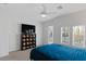 Bright bedroom featuring neutral walls, carpet, ceiling fan, balcony access and a modern storage unit with TV at 6447 Wide Sky St, Las Vegas, NV 89166
