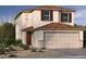 Charming two-story home with a two-car garage and a mix of desert landscaping with native trees and shrubs at 6616 Tumoulin St, Las Vegas, NV 89148