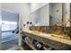 Bright bathroom featuring double sinks with striking stone vanity and ample under-counter storage at 6923 Emerald Springs Ln, Las Vegas, NV 89113