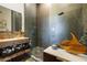 Modern bathroom with stone vanity, a glass-enclosed shower, and unique decorative art piece at 6923 Emerald Springs Ln, Las Vegas, NV 89113