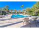 Community pool with lounge chairs and palm trees features clear refreshing water at 6923 Emerald Springs Ln, Las Vegas, NV 89113