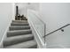 Carpeted staircase featuring modern glass railing, providing a sleek and safe transition between floors at 6923 Emerald Springs Ln, Las Vegas, NV 89113