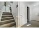 Stairway with carpeted stairs and glass railing, leading to upper level of the home at 6923 Emerald Springs Ln, Las Vegas, NV 89113