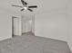 This vacant bedroom has grey carpet, ceiling fan, and three windows at 7200 Mineral Park Ave, Las Vegas, NV 89179