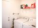 Practical laundry room with white appliances and storage shelf for laundry supplies at 7405 Painted Ridge St, Las Vegas, NV 89131