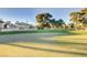 Scenic view of the golf course with mature trees surrounding the green, and a luxury home at 746 Oakmont Ave # 708, Las Vegas, NV 89109