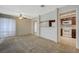 Sunlit carpeted living room featuring a ceiling fan and open passthrough to the kitchen at 746 Oakmont Ave # 708, Las Vegas, NV 89109