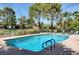 Sparkling swimming pool surrounded by lounge chairs and a lush green landscape at 746 Oakmont Ave # 708, Las Vegas, NV 89109