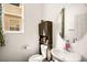 Cozy powder room with a large oval mirror, white fixtures, and tile floors at 7529 Earnshaw Avenue Ct, Las Vegas, NV 89179