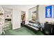 Bright bedroom with green carpet and walk-in closet featuring a black futon, blue artwork, and leafy curtains at 7529 Earnshaw Avenue Ct, Las Vegas, NV 89179