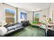 Cozy bedroom with two windows, green carpet and eclectic decor with black sofa and green futon at 7529 Earnshaw Avenue Ct, Las Vegas, NV 89179