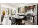 Stylish kitchen with granite countertops, dark cabinets, stainless steel appliances, and breakfast bar at 7529 Earnshaw Avenue Ct, Las Vegas, NV 89179