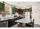 Gourmet kitchen with dark cabinets, stainless appliances, granite counters, and large island at 7529 Earnshaw Avenue Ct, Las Vegas, NV 89179