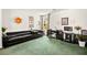 Comfortable living space with a dark leather sofa, desk area, and large bright window at 7529 Earnshaw Avenue Ct, Las Vegas, NV 89179