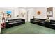 Spacious living room features multiple dark leather sofas and bright natural light at 7529 Earnshaw Avenue Ct, Las Vegas, NV 89179