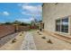 Landscaped backyard with a brick-paved path, low-maintenance desert landscaping, and side yard window at 7579 Harwich Bay Ave, Las Vegas, NV 89179