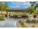 Community gazebo featuring multiple picnic tables and lush, mature landscaping at 7579 Harwich Bay Ave, Las Vegas, NV 89179