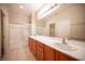 Bathroom featuring double sinks, large mirror and a glass shower enclosure at 7726 Coast Jay St, North Las Vegas, NV 89084