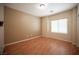 Neutral bedroom featuring wood flooring, a window with blinds and a ceiling light at 7726 Coast Jay St, North Las Vegas, NV 89084